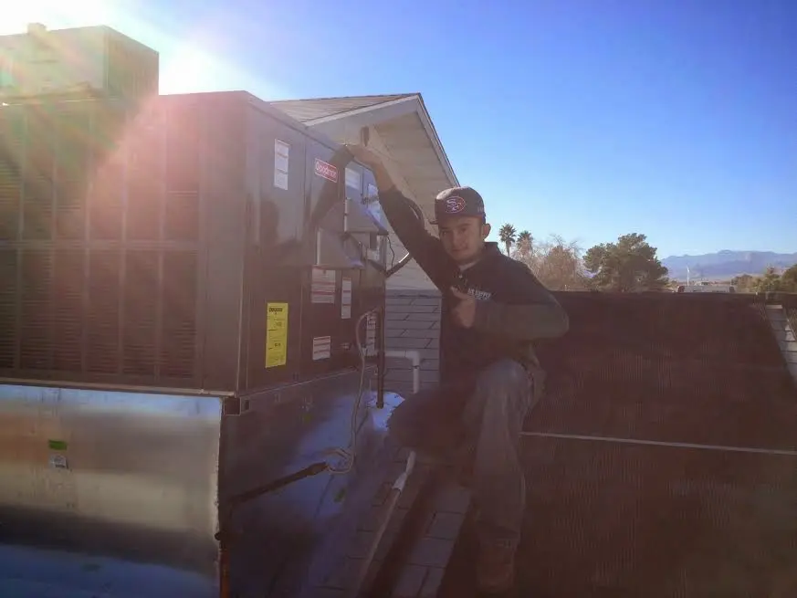HVAC technician performing Heat Pump Repair on a rooftop unit in Springfield